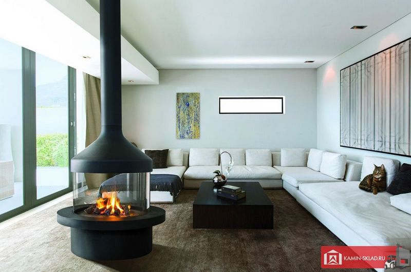 круглый камин перед окном